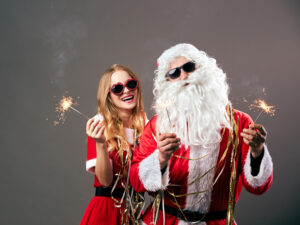 Santa Claus a jeho pomocnice se zábavnými prskavkami v kostýmech