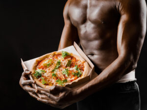 Svalnatý kurýr bez trička nabízí pizzu v krabici