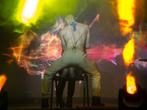 Striptér při ohnivé show tančí na pódiu před divačkou