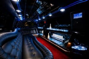 Luxusní interiér bílé limuzíny Lincoln s LED osvětlením, barem a připraveným sektem na rozlučku se svobodou